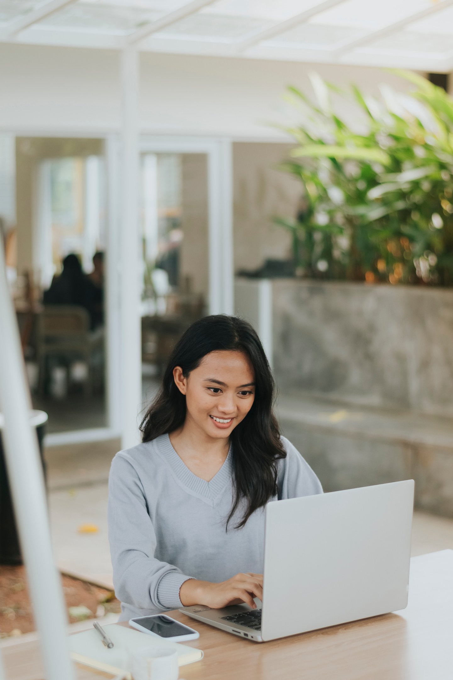 Smiling Woman Using Her Laptop on the Table